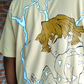 Person wearing a beige t-shirt with an anime-style design on the back.